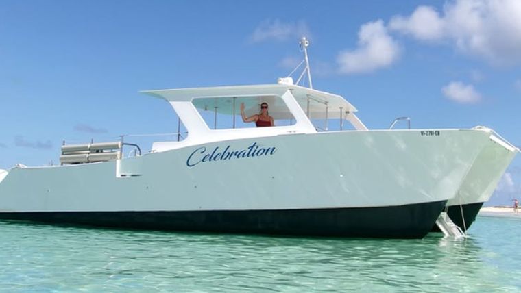Celebration, our 41 ft power catamaran, anchored in clear turquoise shallows off Buck Island