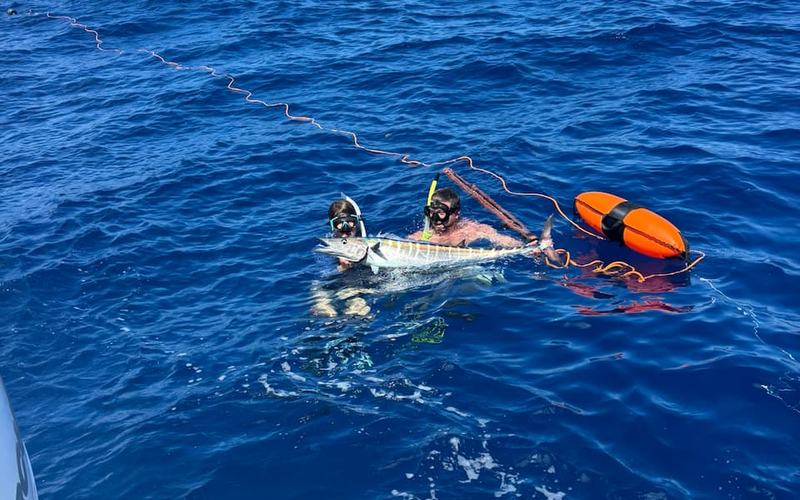 Day Break Charters spearfishing guests with a wahoo in clear blue water off St. Croix