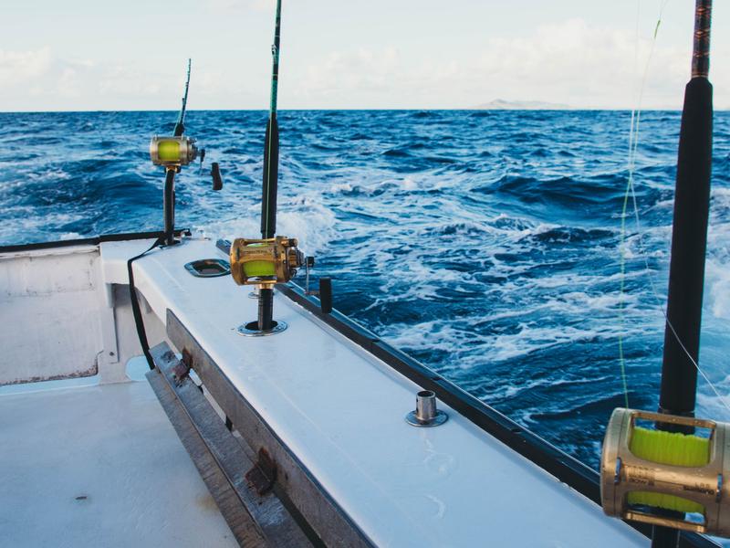 Fishing rods set on the stern of a sport fishing boat on blue water