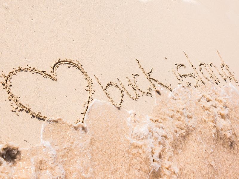 A heart and the words Buck Island drawn in the sand on Turtle Beach
