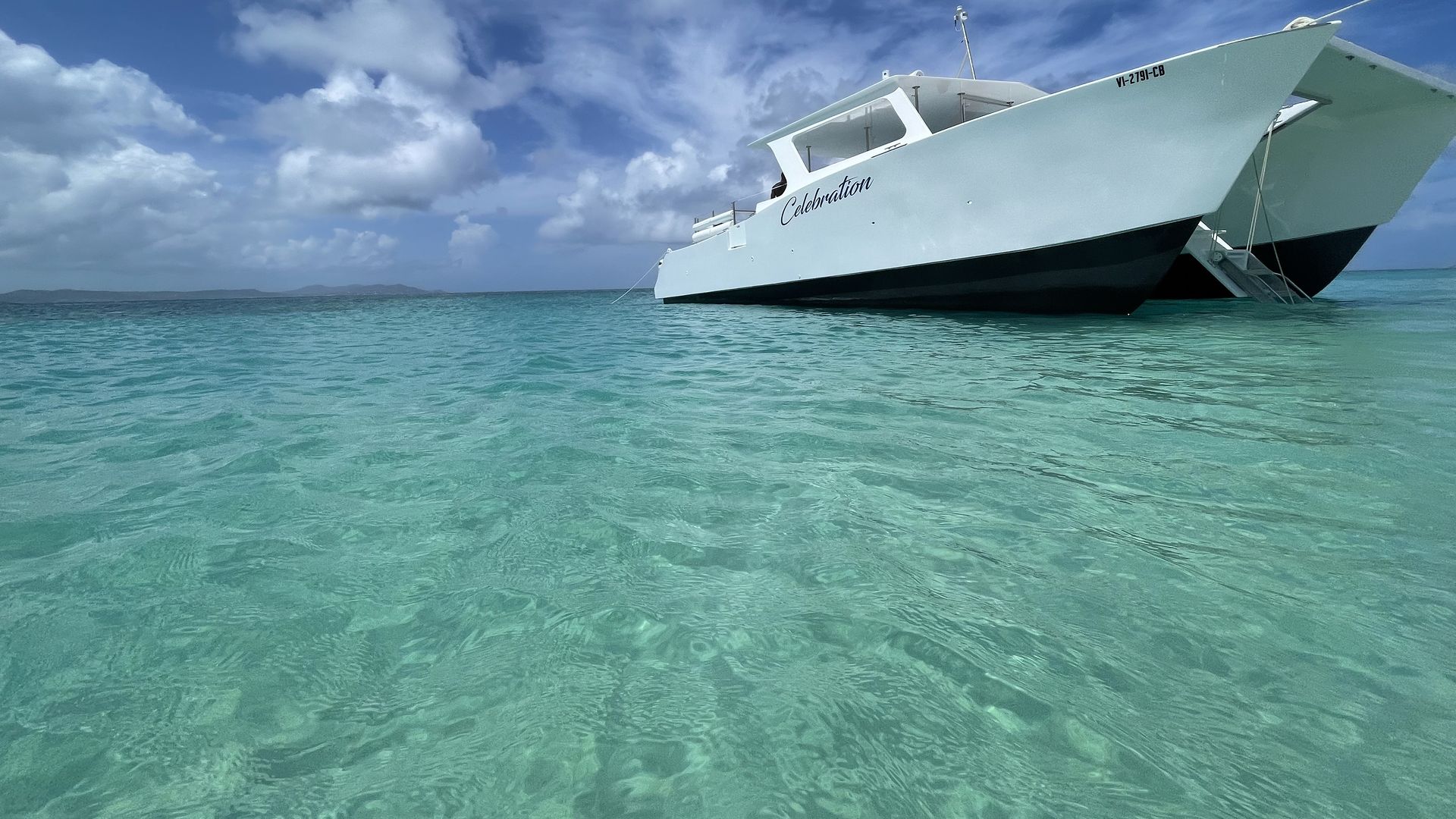 Celebration power catamaran anchored in turquoise water at Buck Island, St. Croix