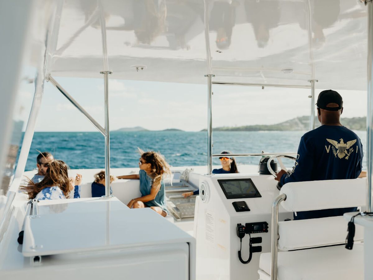 Caribbean Sea Adventures private charter anchored in turquoise water off a white-sand beach