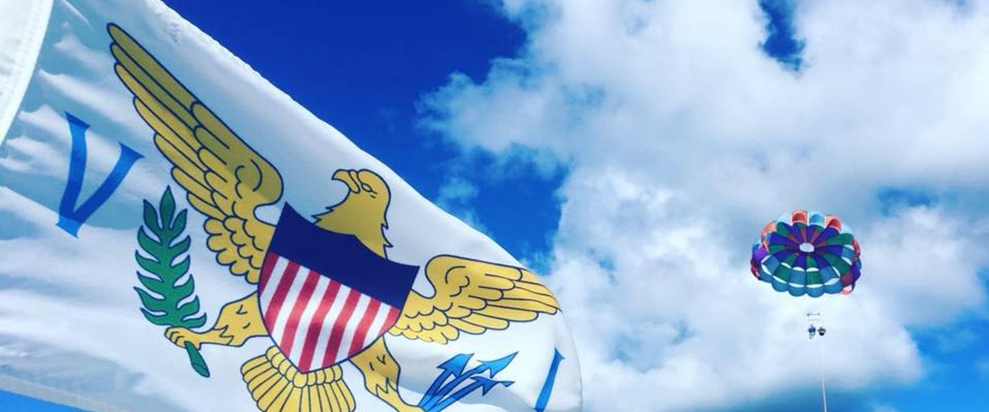 Colorful parasail over Christiansted harbor with the USVI flag flying in the foreground
