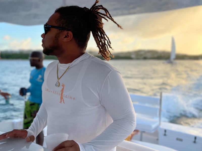 A guest aboard Celebration with a sailboat on the horizon