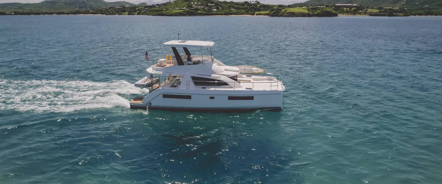 Aerial view of the Good Times power catamaran cruising over deep blue water off St. Croix