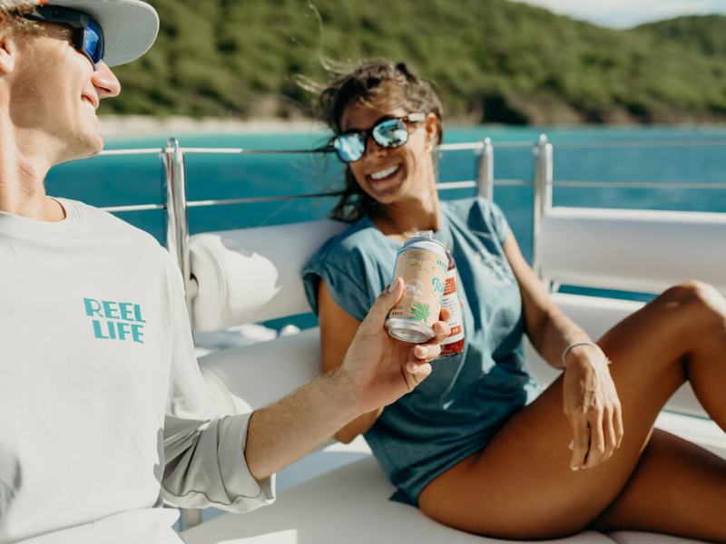 Two guests relaxing on the bow of the Celebration catamaran