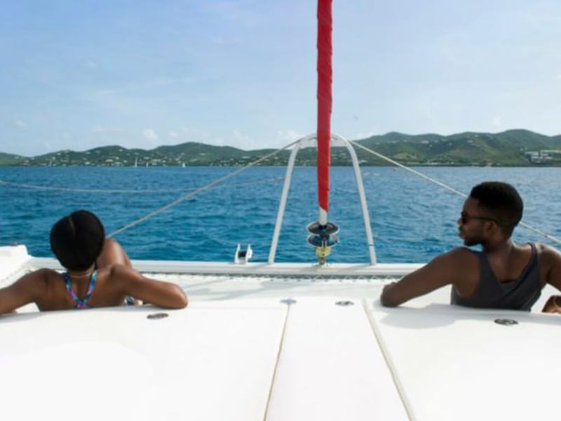 Two guests on the bow of Inconceivable looking toward the island