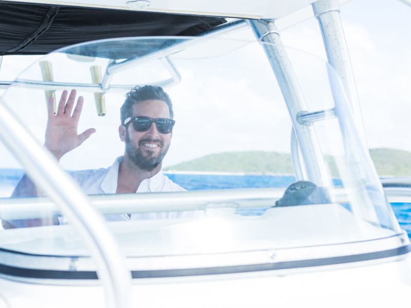 A Caribbean Sea Adventures captain waving from the helm of Smooth Recovery