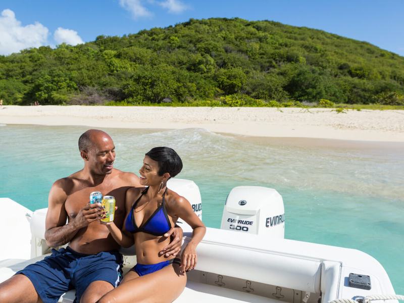 A couple relaxing aboard Smooth Recovery with Buck Island behind them