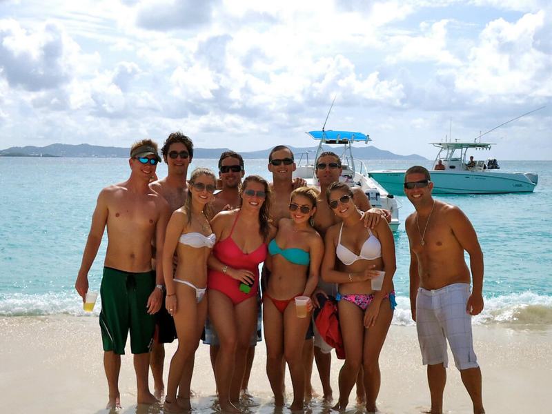 A private charter group posing on the beach with Smooth Recovery in the shallows