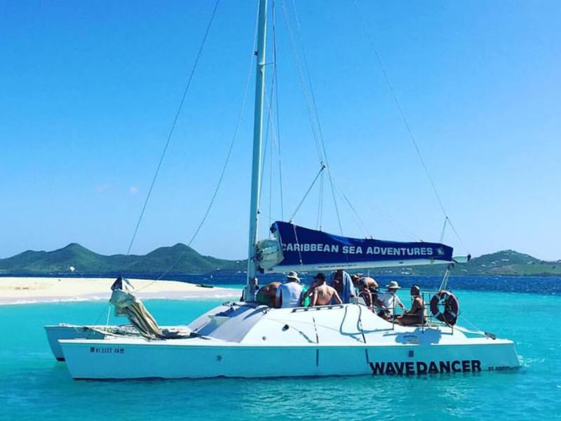 Wave Dancer anchored in turquoise water off a Buck Island beach