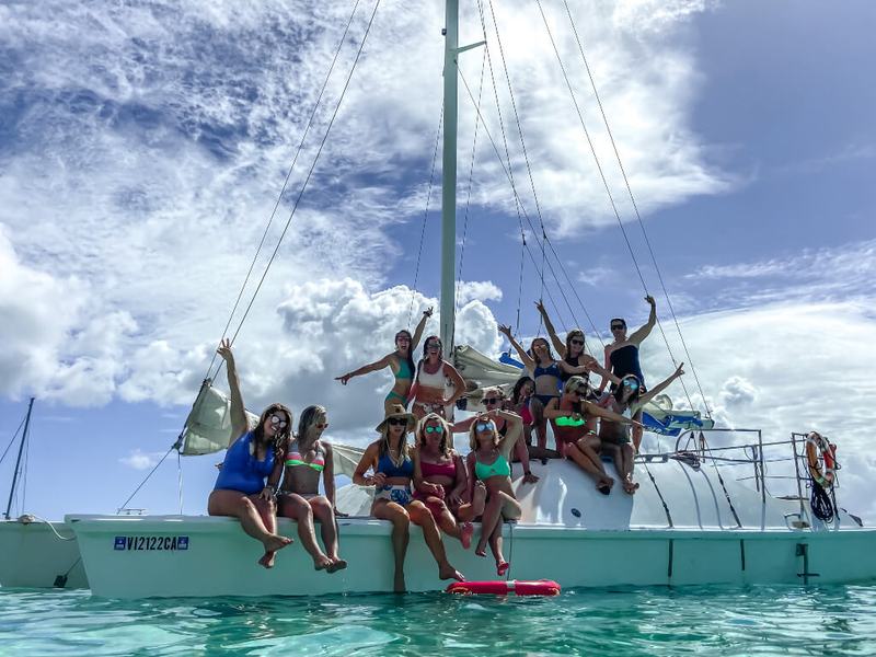 A private group cheering on the deck of the Wave Dancer sailing catamaran