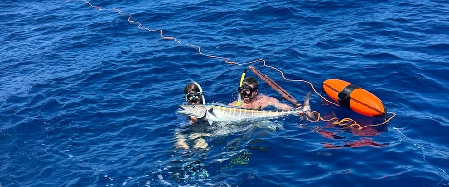 Day Break Charters spearfishing guests with a wahoo in clear blue water off St. Croix